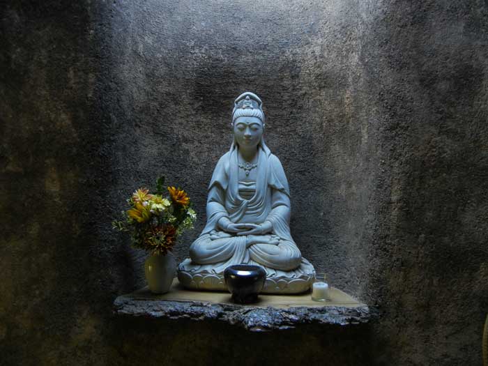 A buddha shrine in a niche inside the garden tool shed at Green Gulch